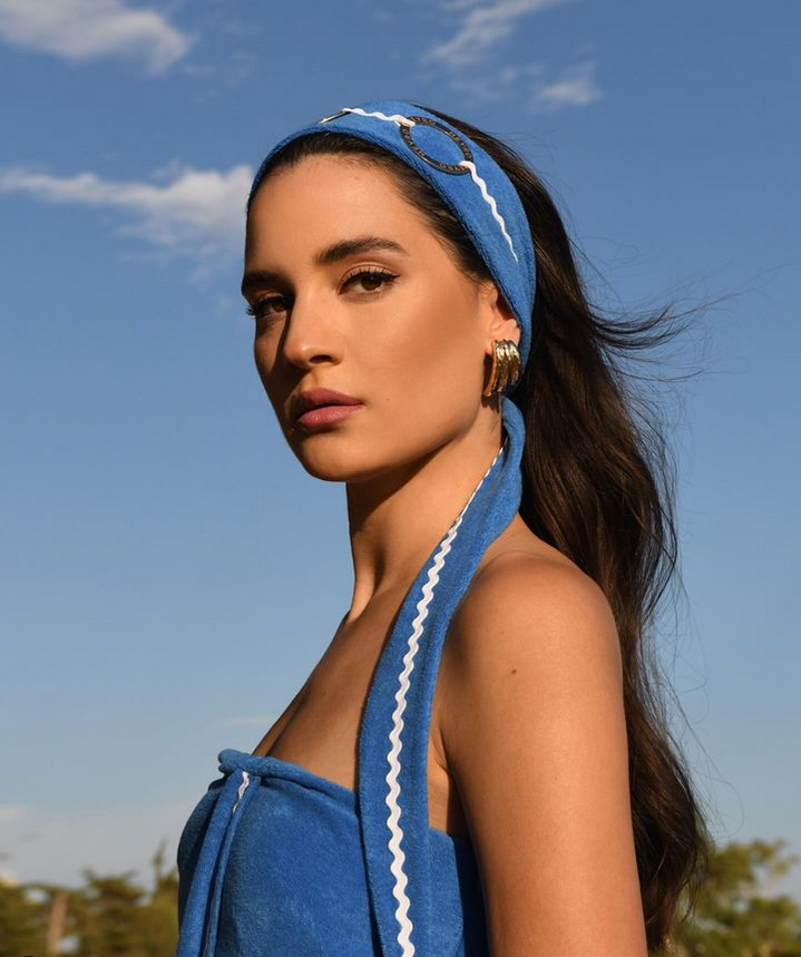 The ICARUS Terry Strapless Dress reimagines Cycladic blue in a breezy, sculptural silhouette—complete with side slit, zigzag trim, and a versatile belt that transforms into a choker or headpiece.