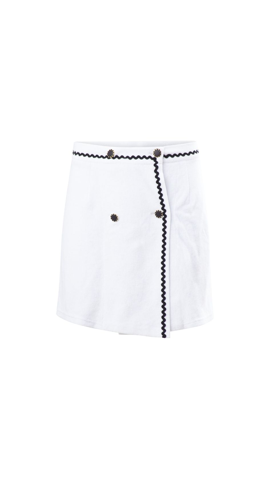 A sculptural take on summer tailoring, this white terry mini skirt features an asymmetrical front, black zig-zag trim, and sunburst buttons—echoing the bold contrast and purity of the Volax landscape.